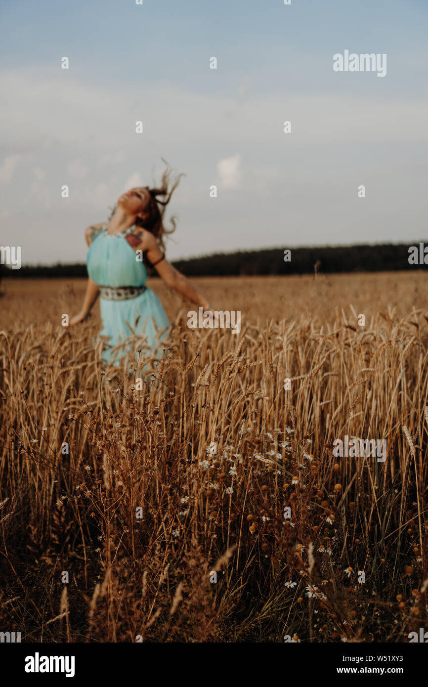 Beautiful Young Woman Dancing In The Field at sunset Stock Photo - Alamy