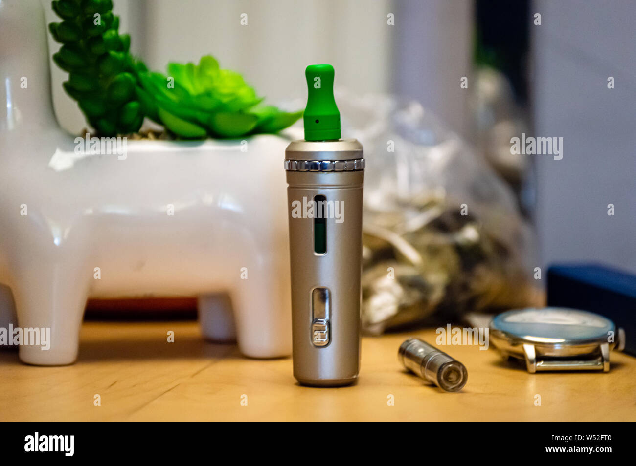 Vape pen with THC CBD oil cartridge vape juice on a nightstand at home. Stock Photo