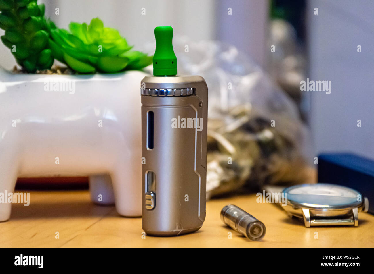 Vape pen with THC CBD oil cartridge vape juice on a nightstand at home. Stock Photo