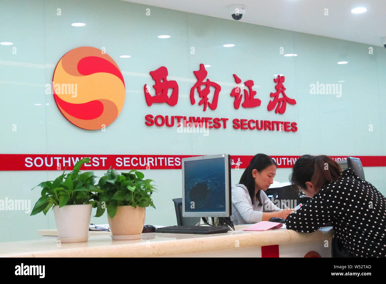 --FILE--Chinese workers are pictured at a branch of Southwest Securities in Shanghai, China, 27 April 2018.   A deputy director at Southwest Securitie Stock Photo