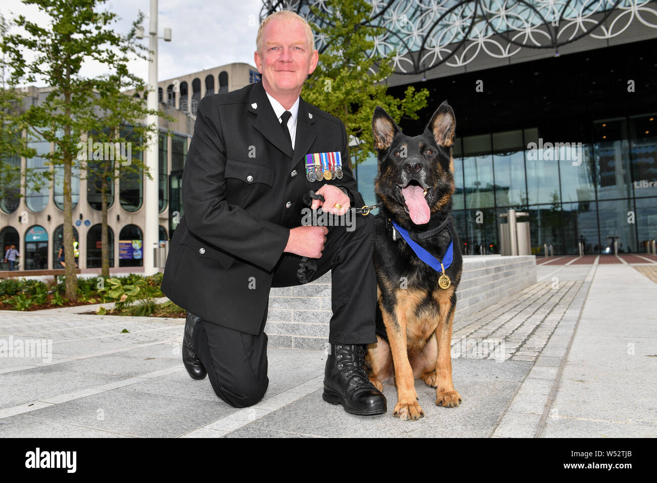 Retired West Mercia Police dog handler PC Mike Davey and retired police dog Bacca, who was brutally stabbed protecting his handler and the public while serving with West Mercia Police, after receiving the PDSA's Gold Medal C which the charity regards as the animal equivalent of the George Cross C following a ceremony at Birmingham Repertory Theatre on Friday. Stock Photo