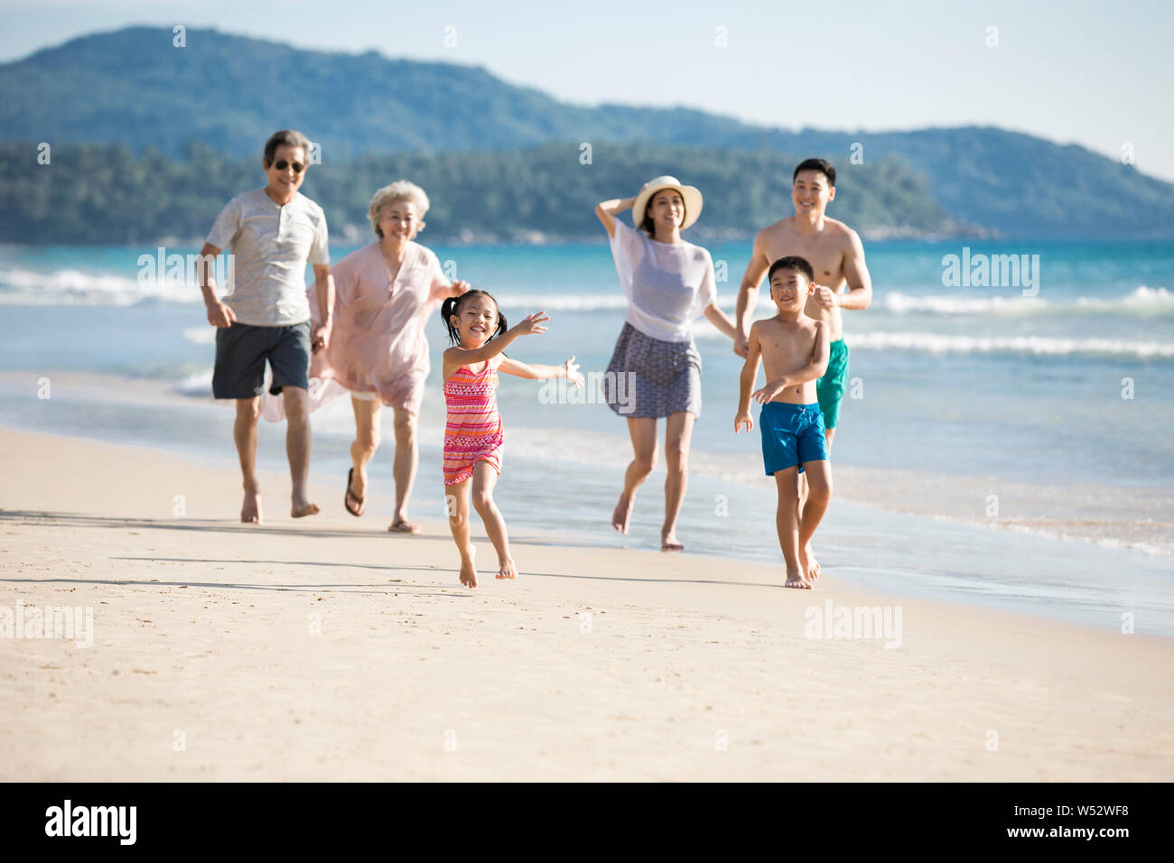 Happy family running on beach hi-res stock photography and images - Alamy