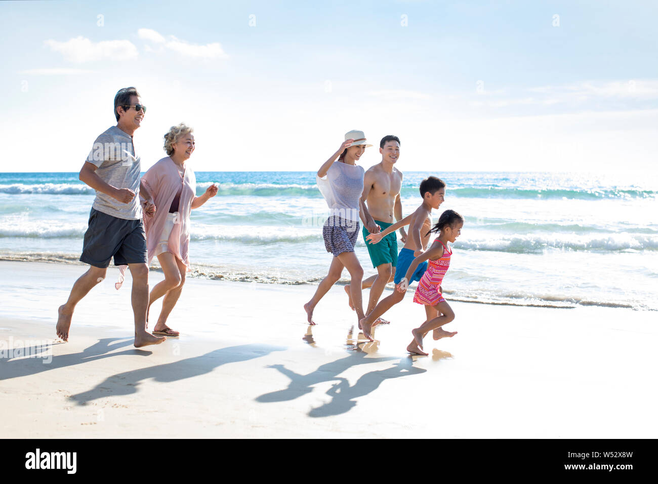 Happy family running on beach hi-res stock photography and images - Alamy