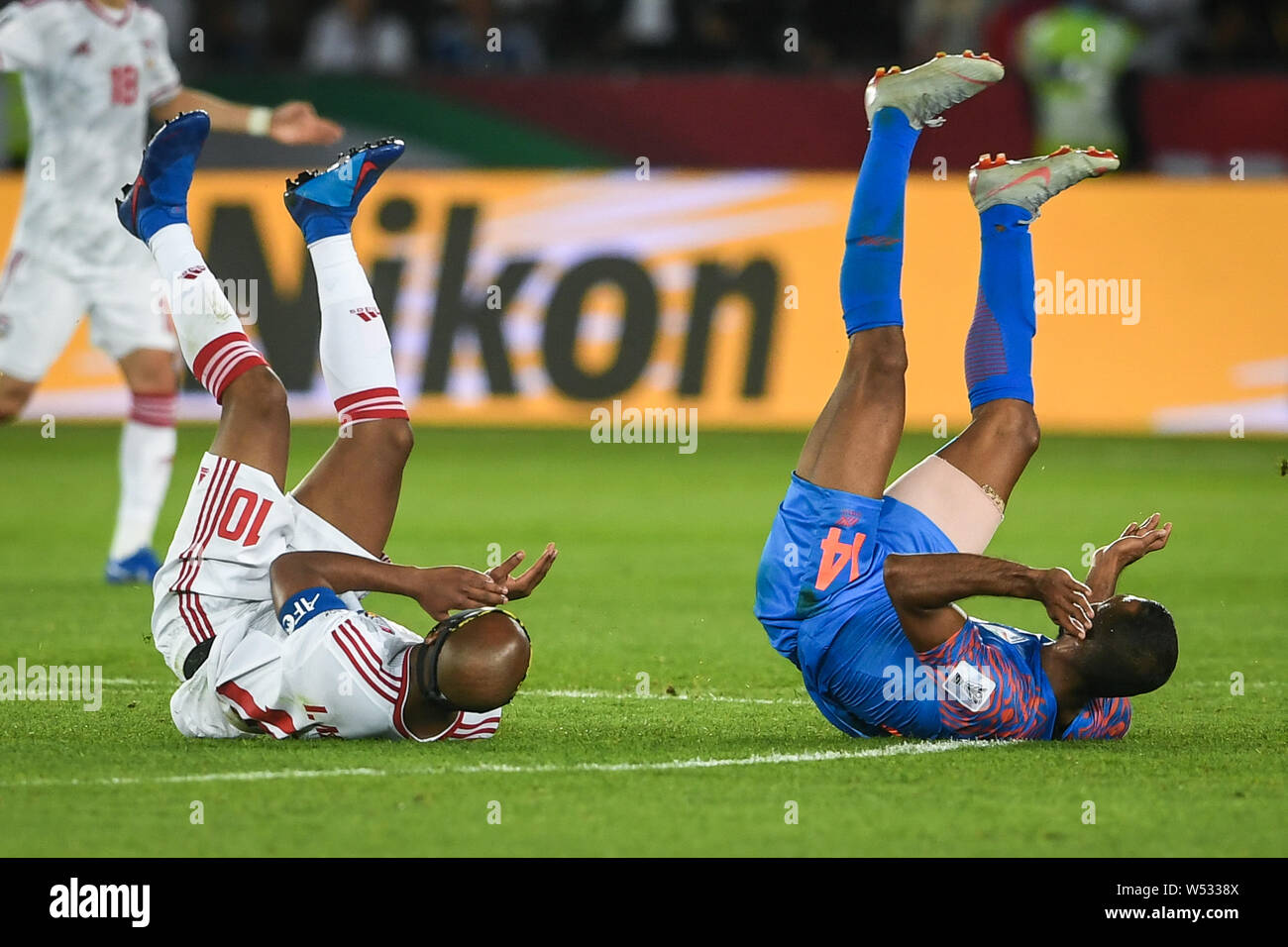 Ismail Matar, left, of United Arab Emirates national football team and Pronay Halder of India national football team tumble down in the AFC Asian Cup Stock Photo