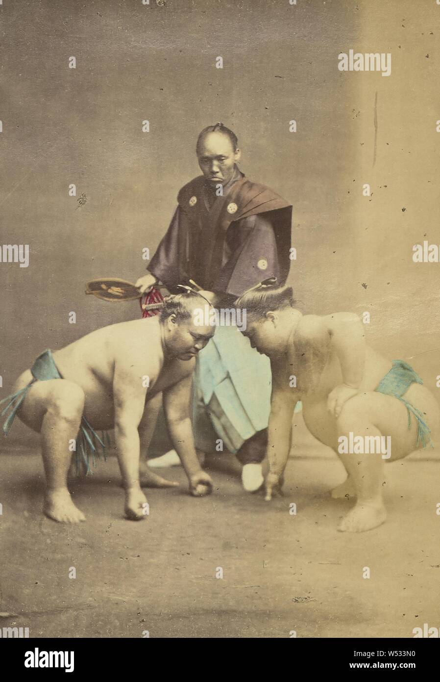 Two Japanese Sumo Wrestlers Posed with Referee, Felice Beato (English, born Italy, 1832 - 1909), or Baron Raimund von Stillfried (Austrian, 1839 - 1911), Japan, 1868–1880, Hand-colored albumen silver print, 13.8 × 9.5 cm (5 7/16 × 3 3/4 in Stock Photo
