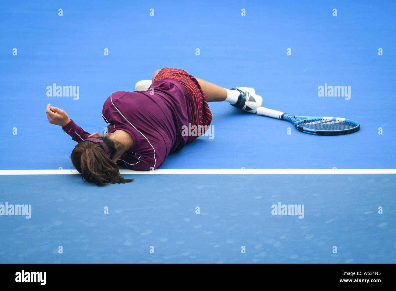 Wang Xinyu of China falls down while competing against Maria Sharapova of Russia in their second round match of the women's singles during the 2019 WT Stock Photo