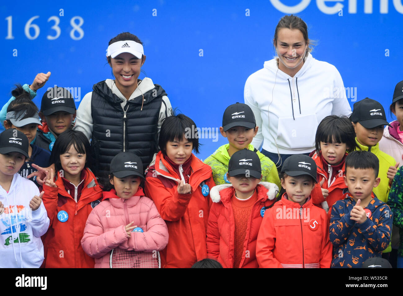 Wang Qiang, center left, of China, and Aryna Sabalenka, center right, of Belarus poses for photos with little fans ahead of the 2019 WTA Shenzhen Open Stock Photo