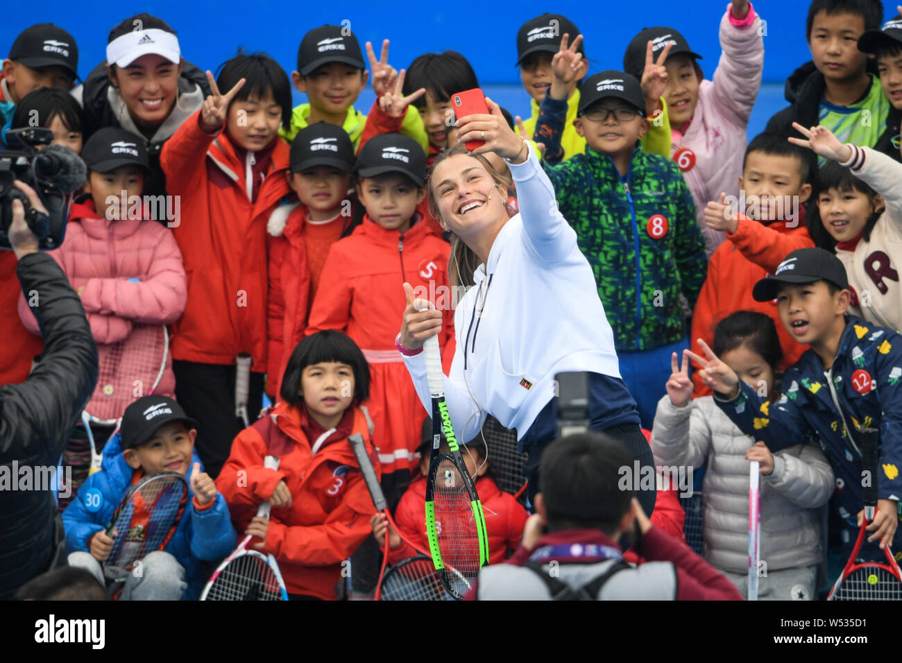 Aryna Sabalenka, front, of Belarus takes selfies with little fans ahead of the 2019 WTA Shenzhen Open tennis tournament in Shenzhen city, south China' Stock Photo