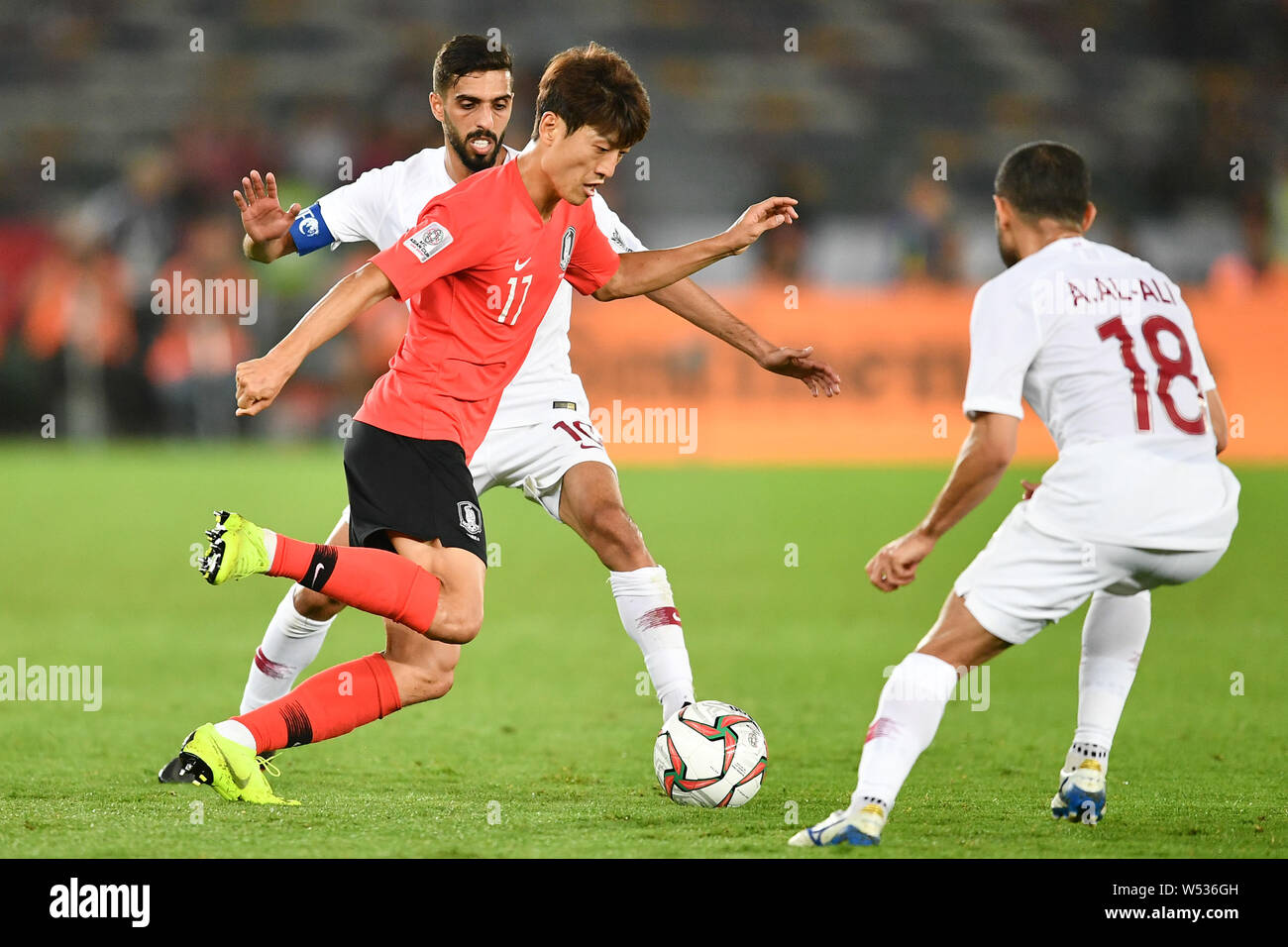 Lee Chung-yong, center, of South Korea national football team passes the ball against players of Qatar national football team in their quarter-final m Stock Photo