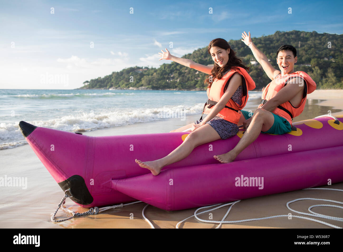 Happy young couple enjoying banana boat ride Stock Photo