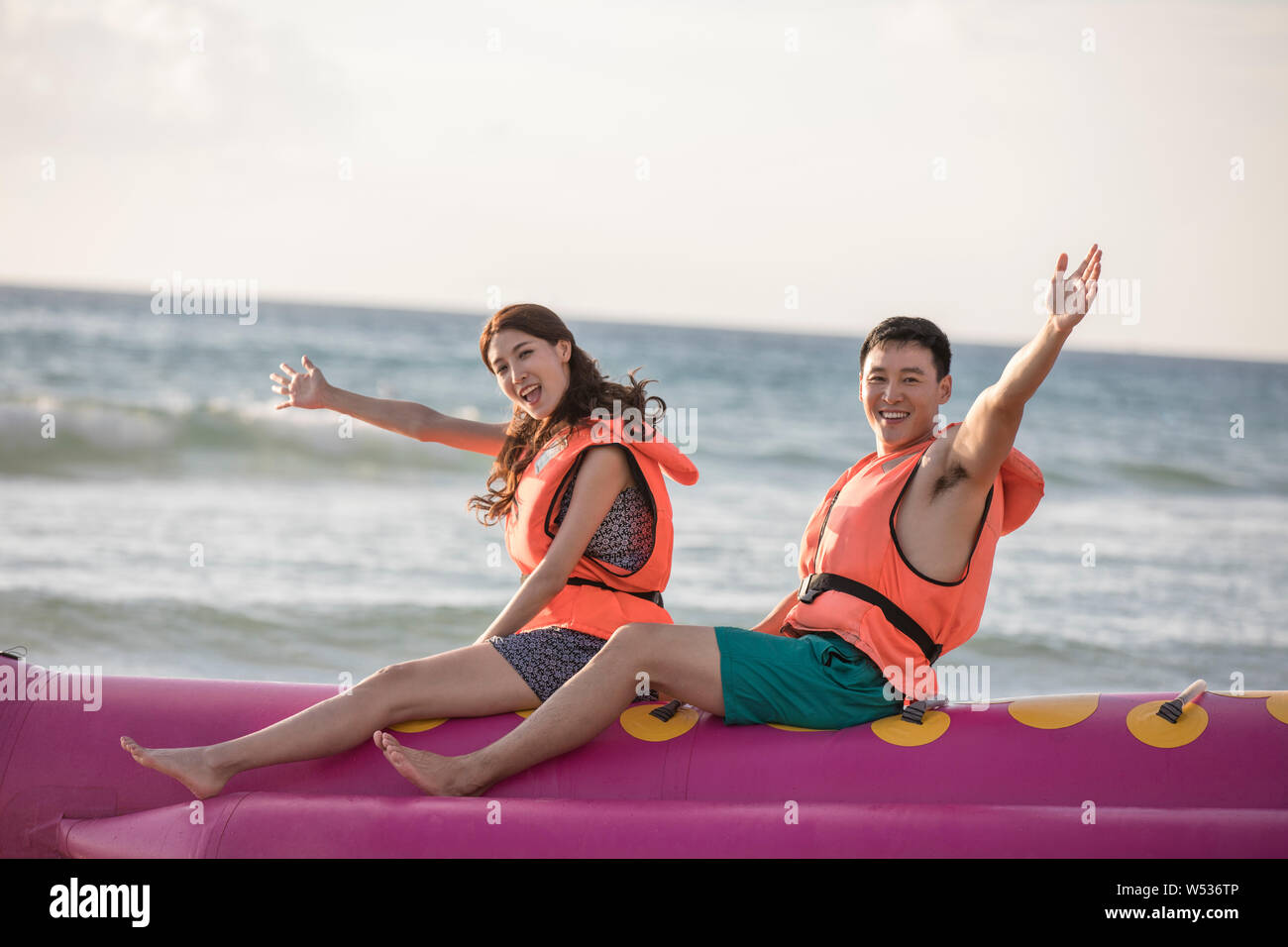 Happy young couple enjoying banana boat ride Stock Photo