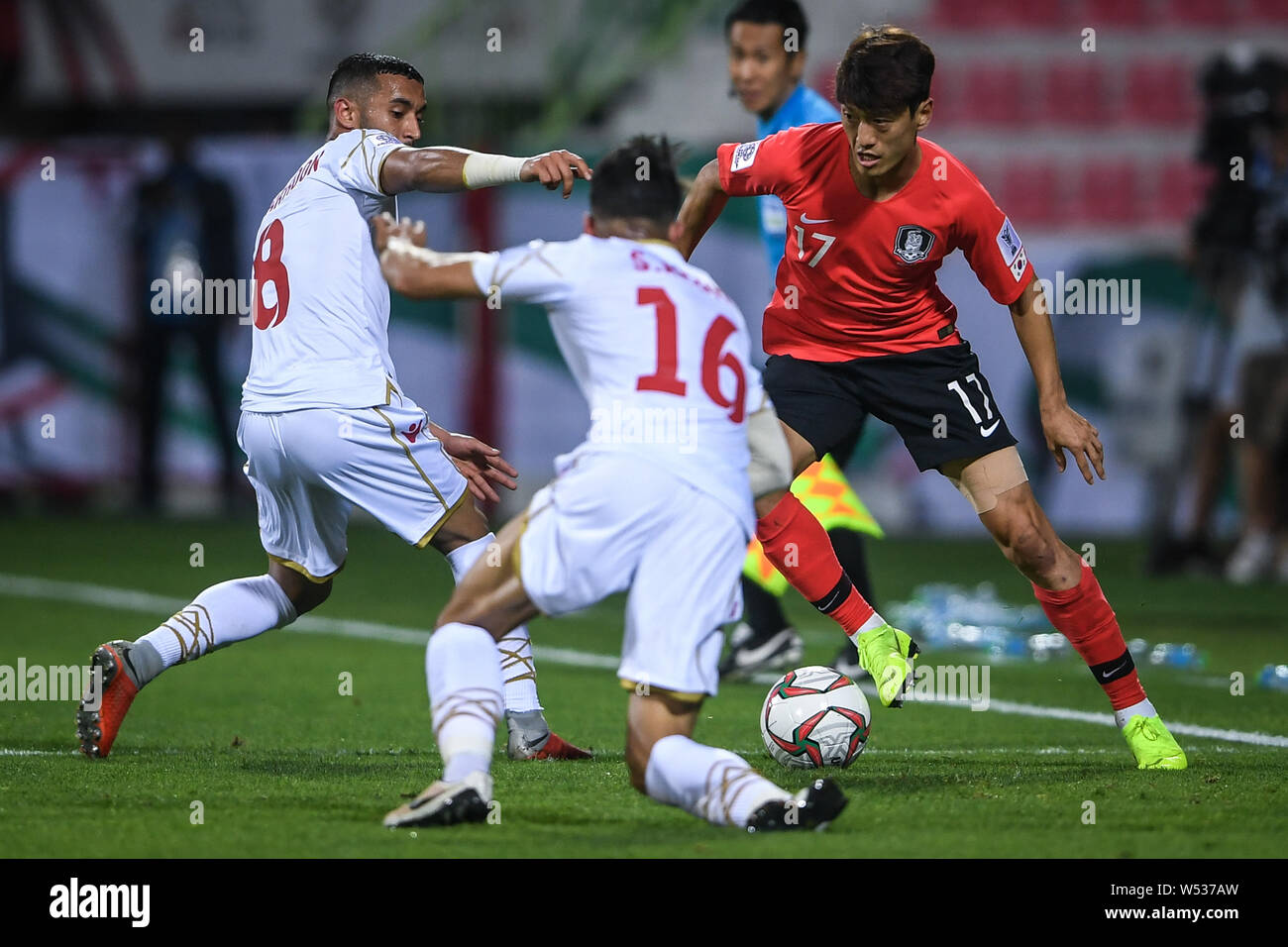 Lee Chung-yong, right, of South Korea challenges Mohamed Marhoon and Sayed Redha Isa of Bahrain in the round of 16 match between South Korea and Bahra Stock Photo