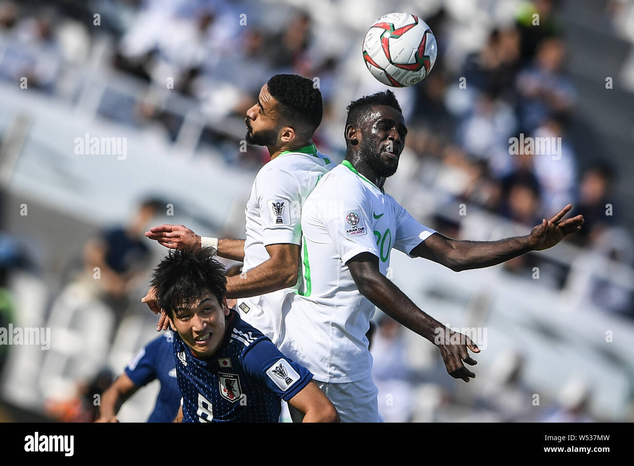 Genki Haraguchi of Japan, front, heads the ball against Mohammed Al-Breik and Abdulaziz Al-Bishi of Saudi Arabia in the round of 16 match between Japa Stock Photo