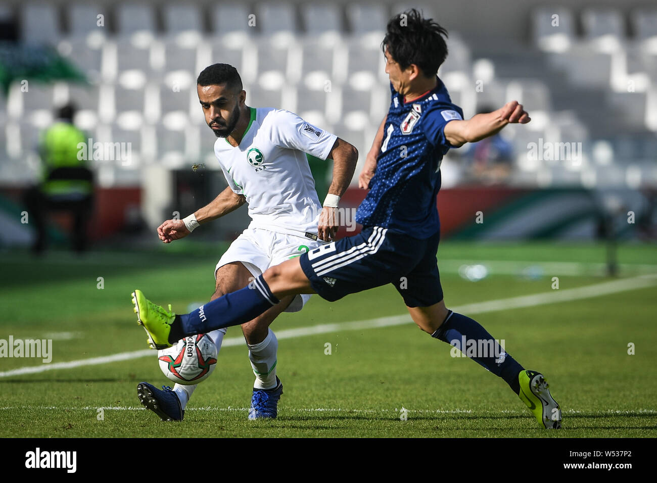 Genki Haraguchi of Japan, right, dribbles against Mohammed Al-Breik of Saudi Arabia in the round of 16 match between Japan and Saudi Arabia during the Stock Photo