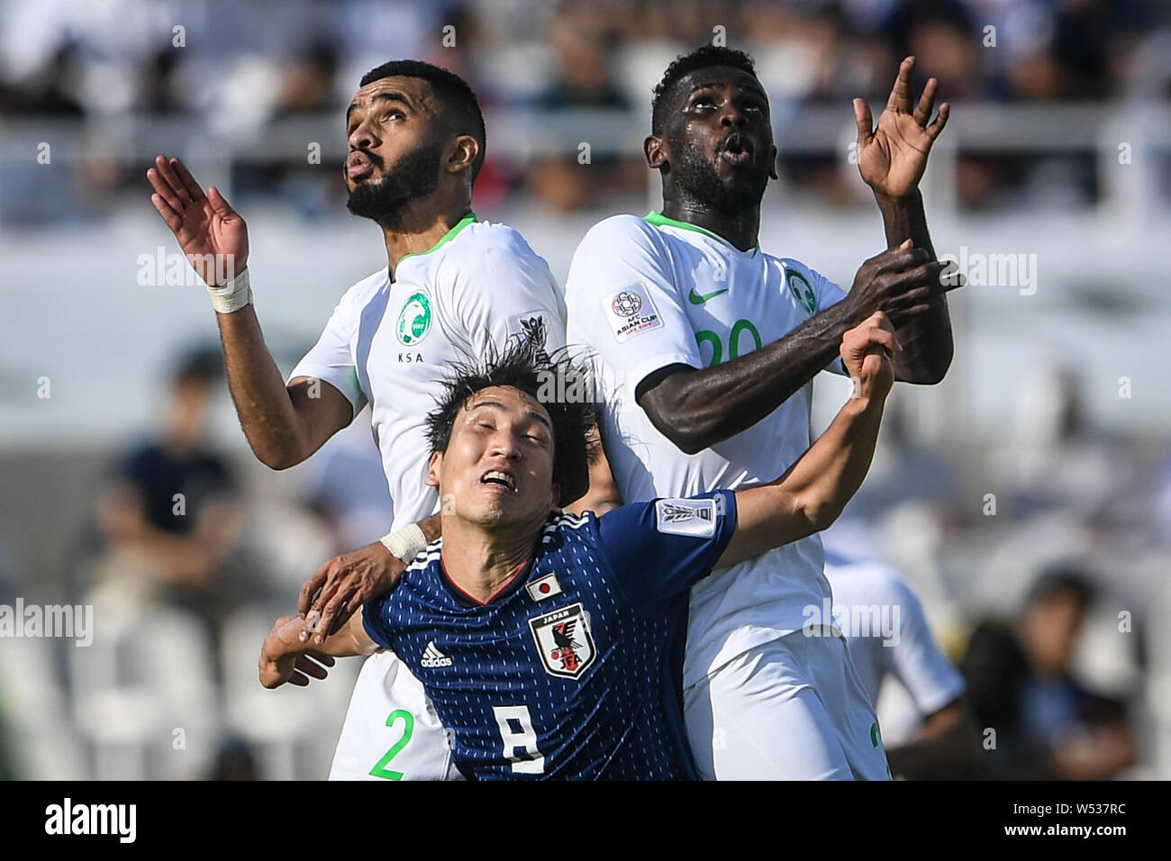 Genki Haraguchi of Japan, below, heads the ball against Mohammed Al-Breik and Abdulaziz Al-Bishi of Saudi Arabia in the round of 16 match between Japa Stock Photo