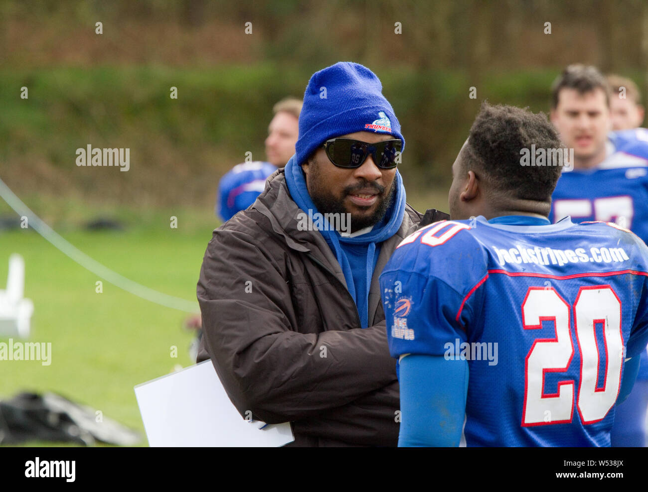 Player and coach in discussion on the sideline Stock Photo