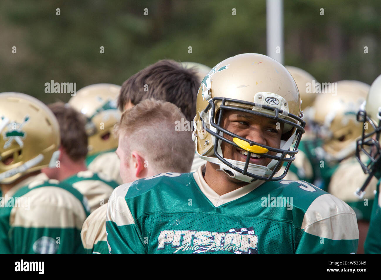 Player on on the sideline with mouth guard poked into face guard Stock Photo