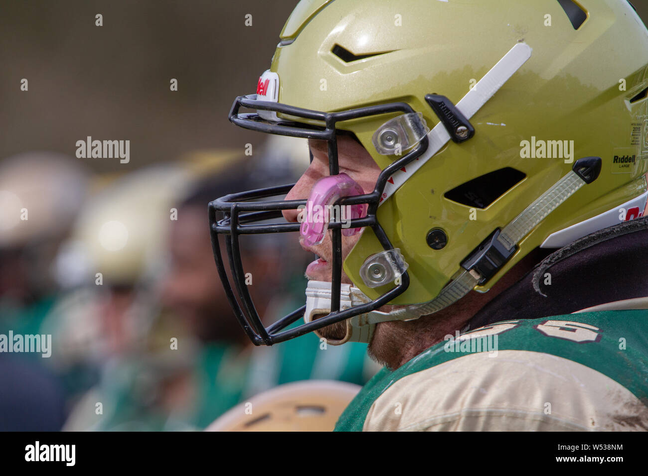 Player on on the sideline with mouth guard poked into face guard Stock Photo