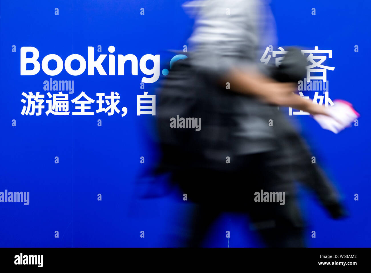 A passenger walks past an advertisement for online hotel reservation site Booking.com at a metro station in Shanghai, China, 29 December 2018.   Booki Stock Photo