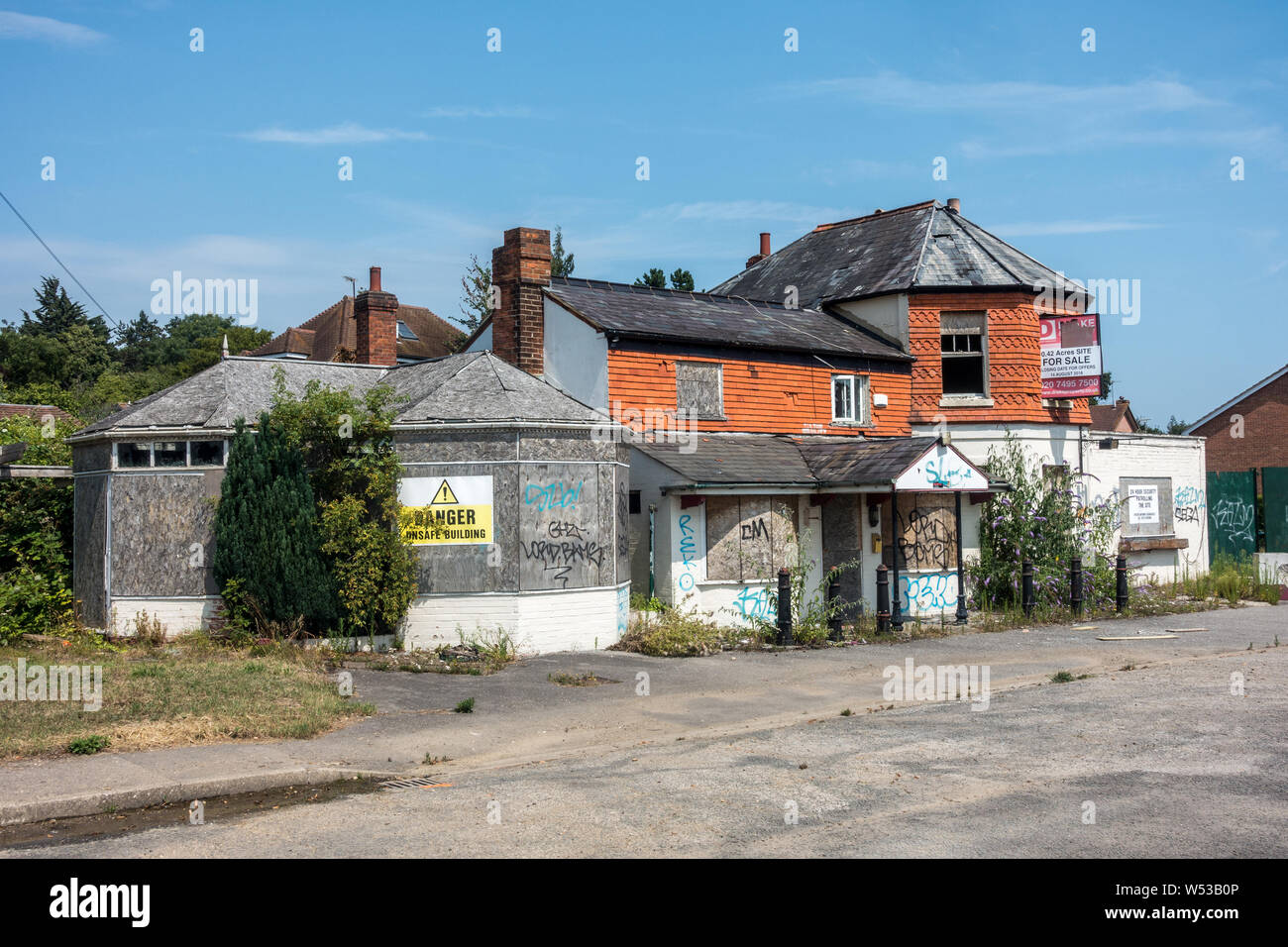 An old closed down pub on the bath road in Reading, UK. It is left vacant and derelict and is a target for vandalism and graffiti. Stock Photo