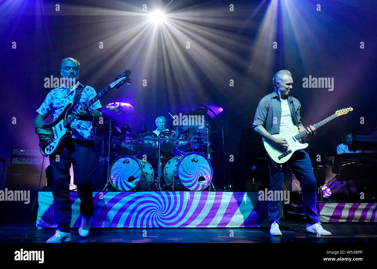 Prague, Czech Republic. 25th July, 2019. Guitarist Guy Pratt of Saucerful Of Secrets, the band led by Pink Floyd drummer Nick Mason (centre), perform in Lucerna Hall, Prague, Czech Republic, on Thursday, July 25, 2019. On the front there are guitarists Guy Pratt, left, and Gary Kemp. Credit: Vit Simanek/CTK Photo/Alamy Live News Stock Photo