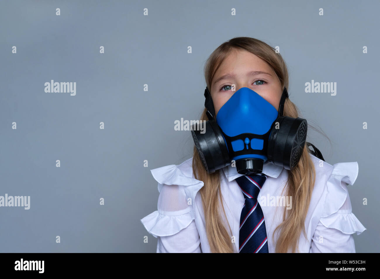 Young schoolchild in gasmask closeup portrait. Effect of pollution on small children, preteens. Dangerous environmental changes affecting younger gene Stock Photo