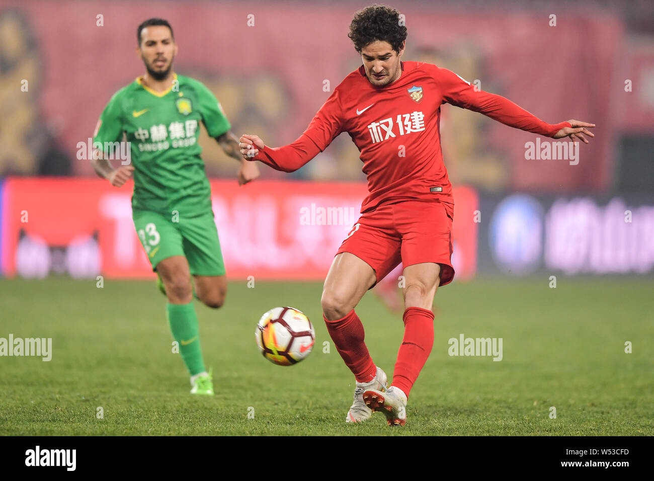 --FILE--Brazilian football player Alexandre Rodrigues da Silva, known as Pato, of Tianjin Quanjian passes the ball against a player of Beijing Sinobo Stock Photo