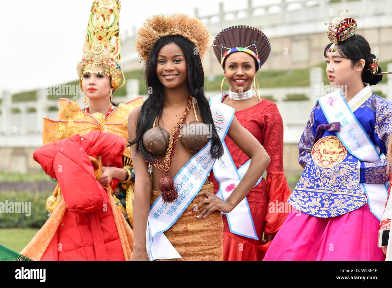 Contestants dressed in traditional costumes take part in an outdoor photo session for the 53th Miss All Nationsl Pageant in Nanjing city, east China's Stock Photo