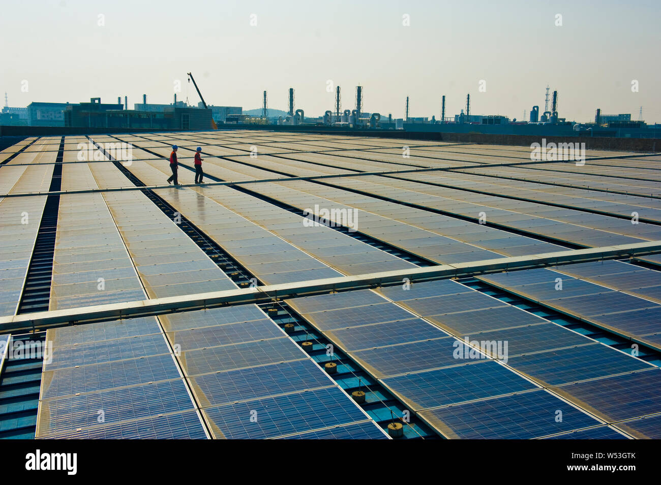 --FILE--Chinese workers check solar panels at a rooftop in Haining city, east China's Zhejiang province, 8 November 2013.      A spin-off of the world Stock Photo