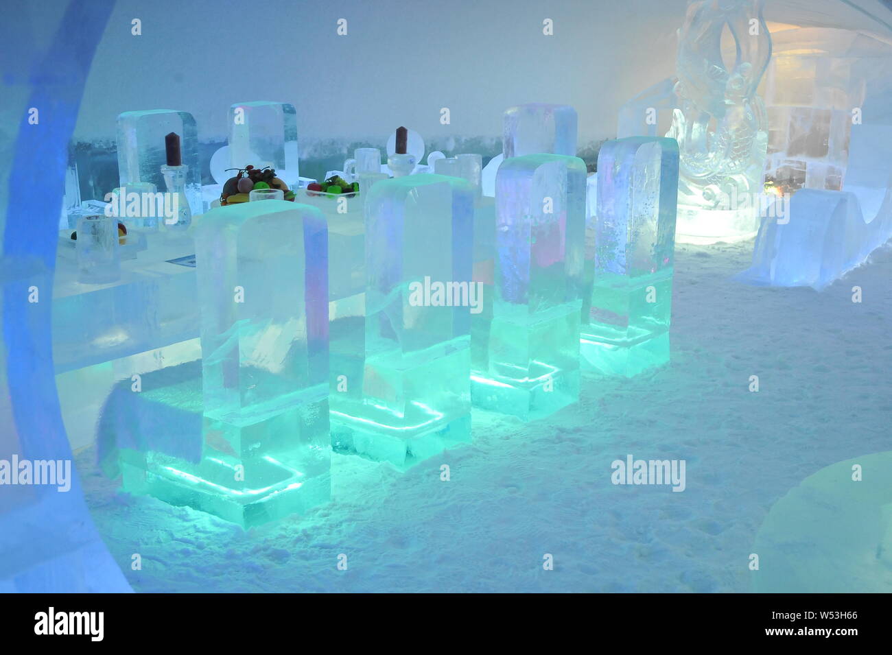 An ice table and ice chairs are on display at an archshaped ice hotel