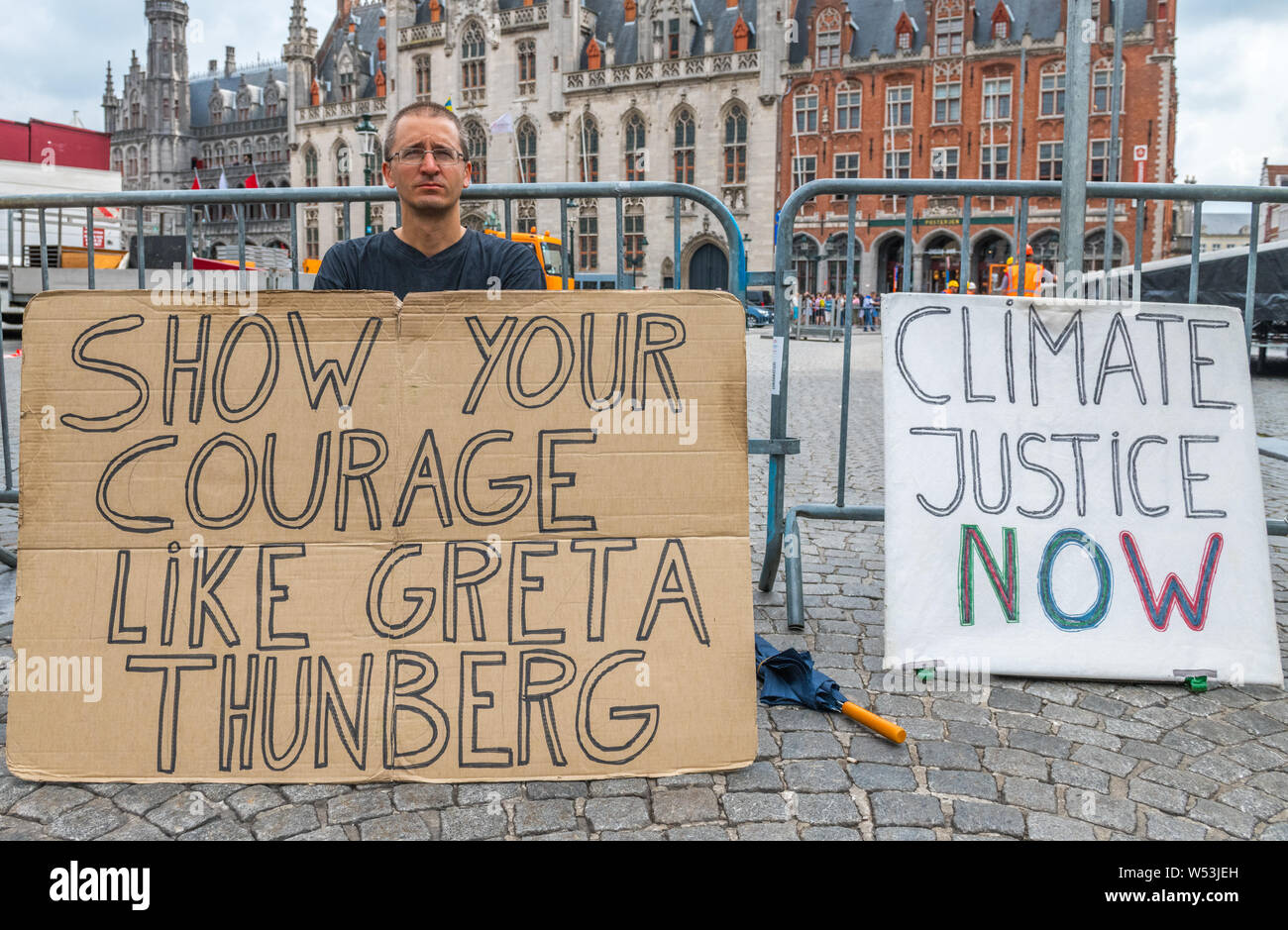 Wouter Mouton, a climate change activist with his carboard placards in the centre of Bruges, Belgium. Stock Photo