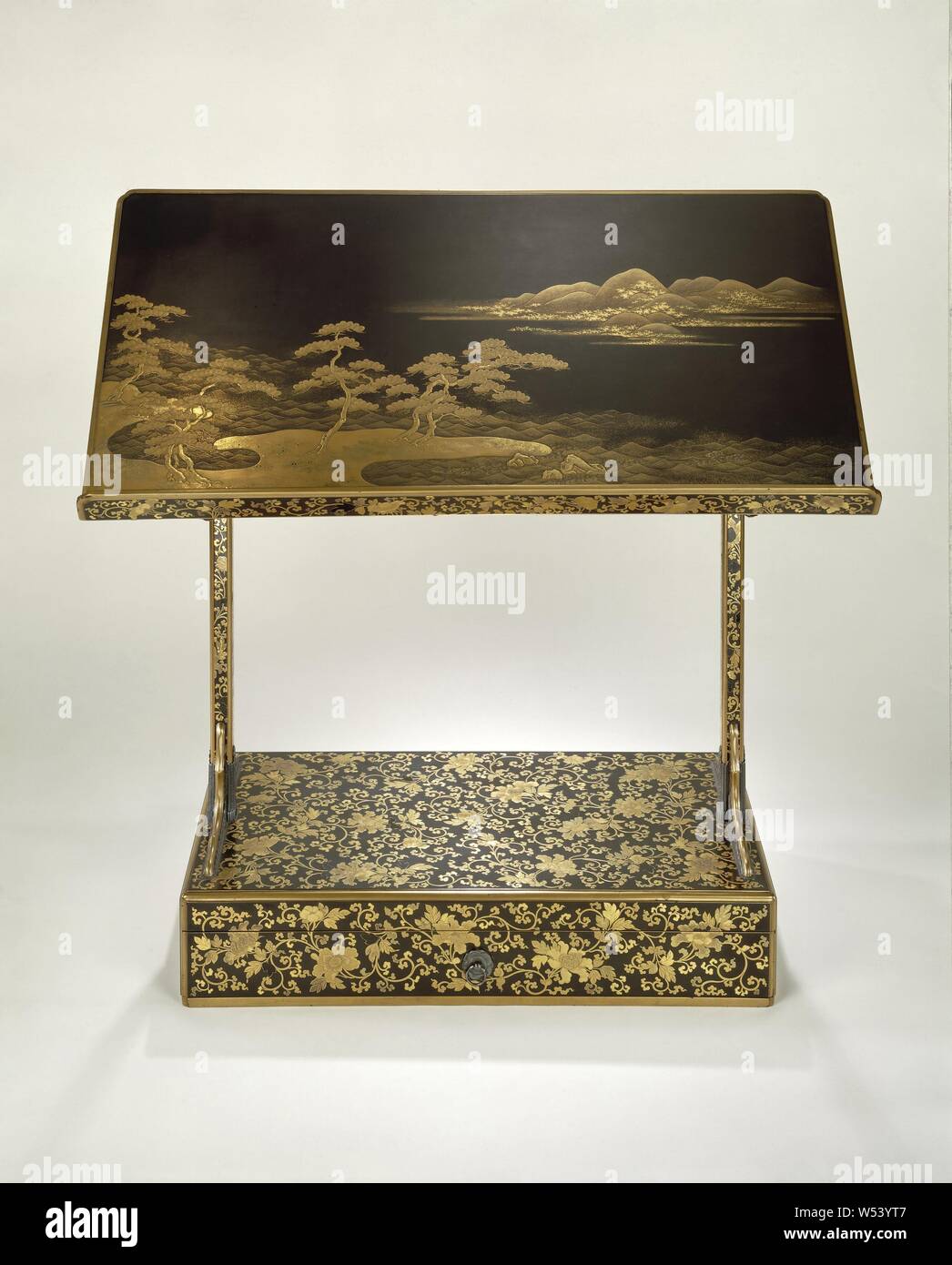 Reading stand Lectern, Lectern with a representation of pine trees on the beach of Sumiyoshi in gold lacquer and gold leaf against a black background. Legs and base are decorated with peonies and tendrils., anonymous, Japan, c. 1700 - c. 1800, Edo-period (1600-1868), wood (plant material), lacquer (coating), gold (metal), h 58.0 cm × w 60.0 cm × d 25.5 cm × w 3.4 kg Stock Photo