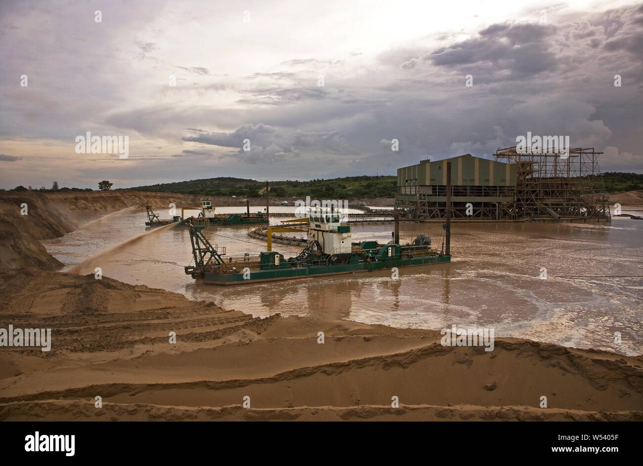 Managing & transporting of titanium mineral sands at mine site. Mining by dredging in freshwater ponds. Dredges pump sand into wet concentrator plant. Stock Photo