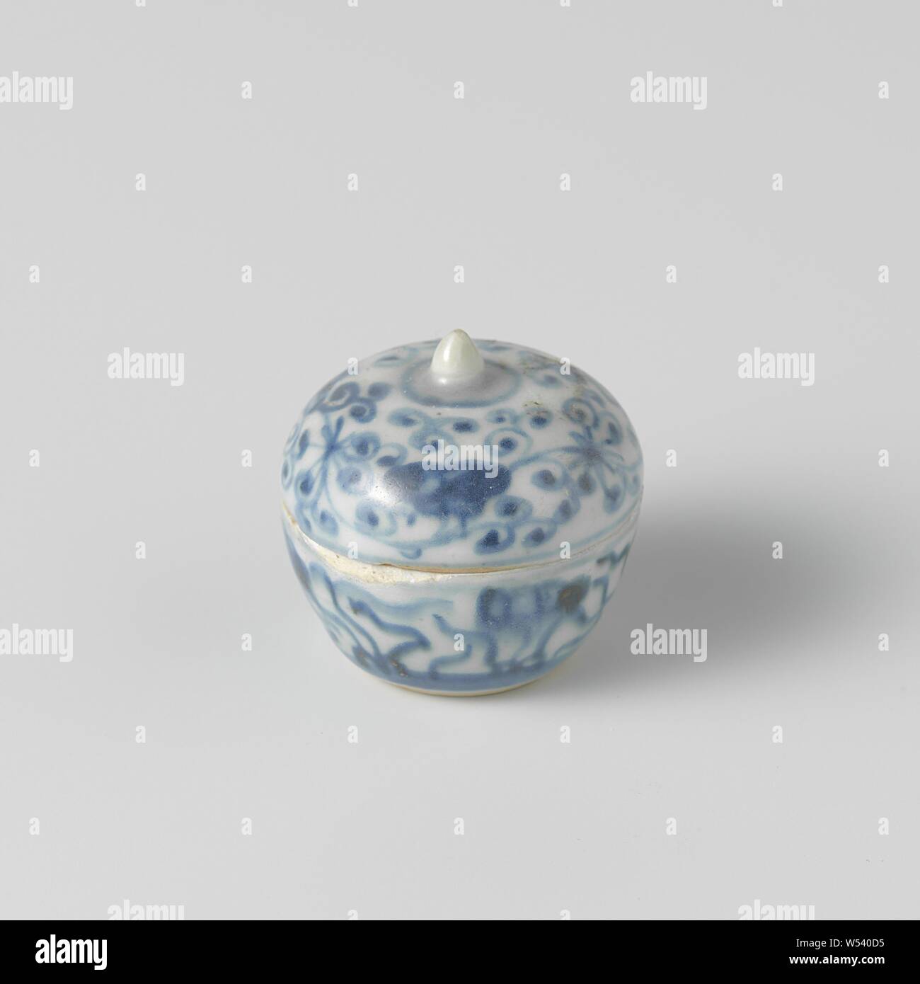 Round box with floral scrolls, Round box made of porcelain with a cone-shaped lid knob, painted in underglaze blue. The box is covered with flower vines and mushrooms (lingzhi). Transition porcelain in blue and white, ornament derived from plant forms, anonymous, China, c. 1650, Qing-dynasty (1644-1912) / Shunzhi-period (1644-1661), porcelain (material), glaze, cobalt (mineral), vitrification, h 4.2 cm d 4.3 cm Stock Photo