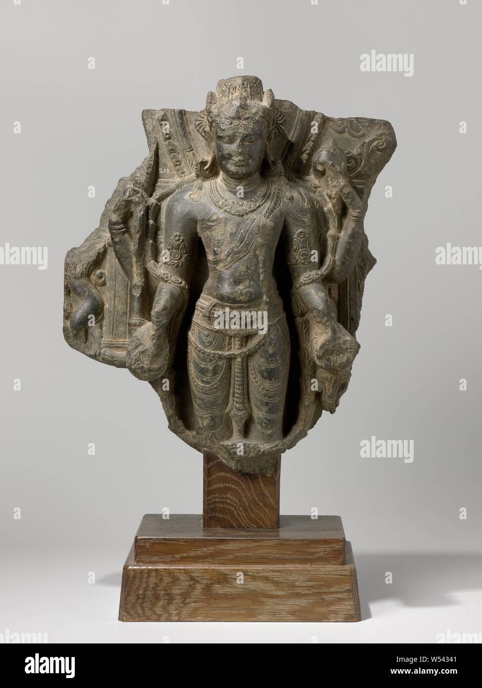 Vishnu, Image of Vishnu, black stone sculpture in the background and damaged on the sides. On base., anonymous, Noordoost-India, 900 - 1000, sokkel, h 49.1 cm h 36.0 cm × w 31.1 cm × d 11.3 cm h 7.6 cm w 22.0 cm × d 14.0 cm × w 14.4 kg Stock Photo
