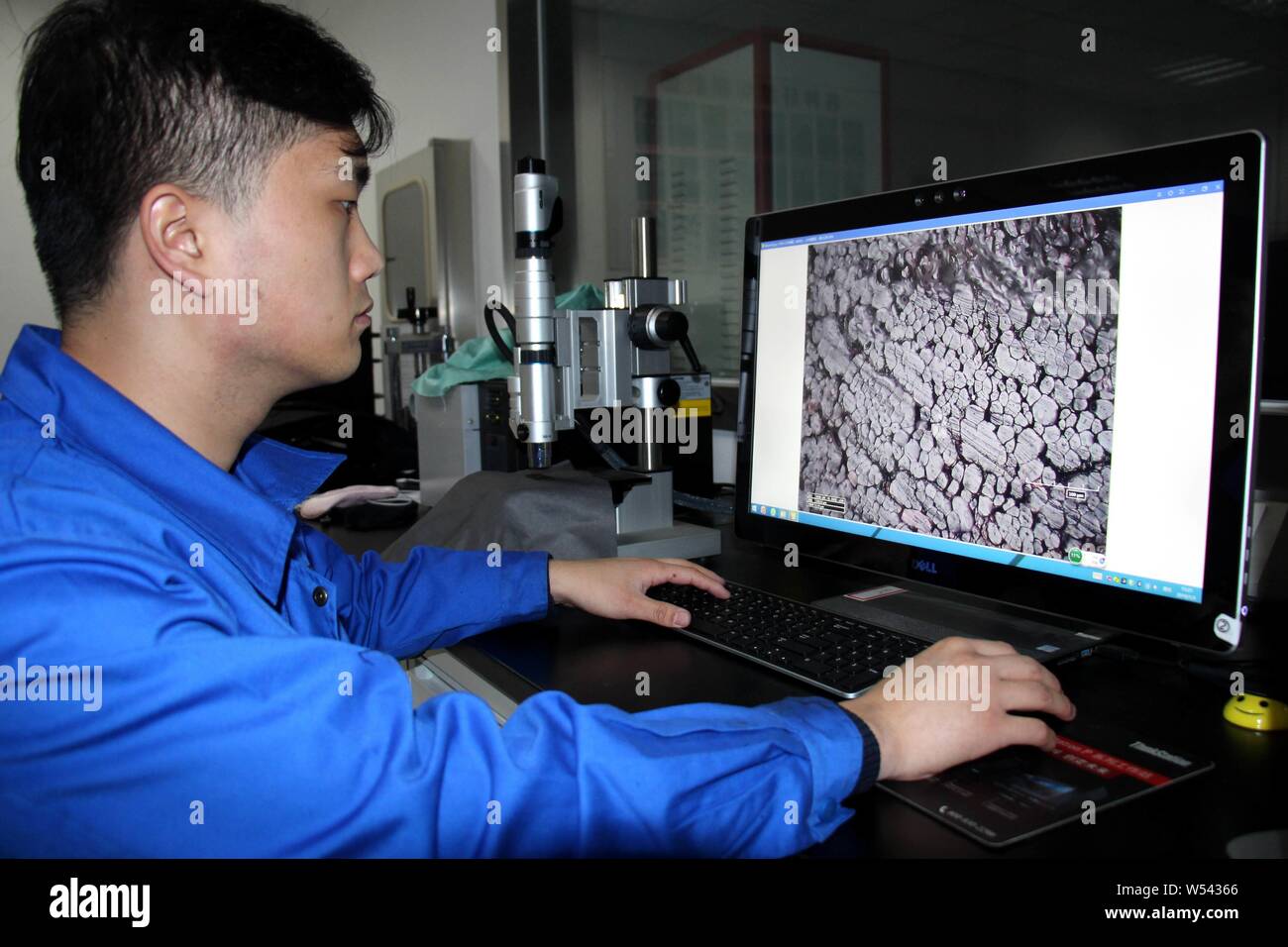 A Chines worker uses a scanning electron microscope to observe the structure of China's first far infrared conductive heating fiber developed based on Stock Photo