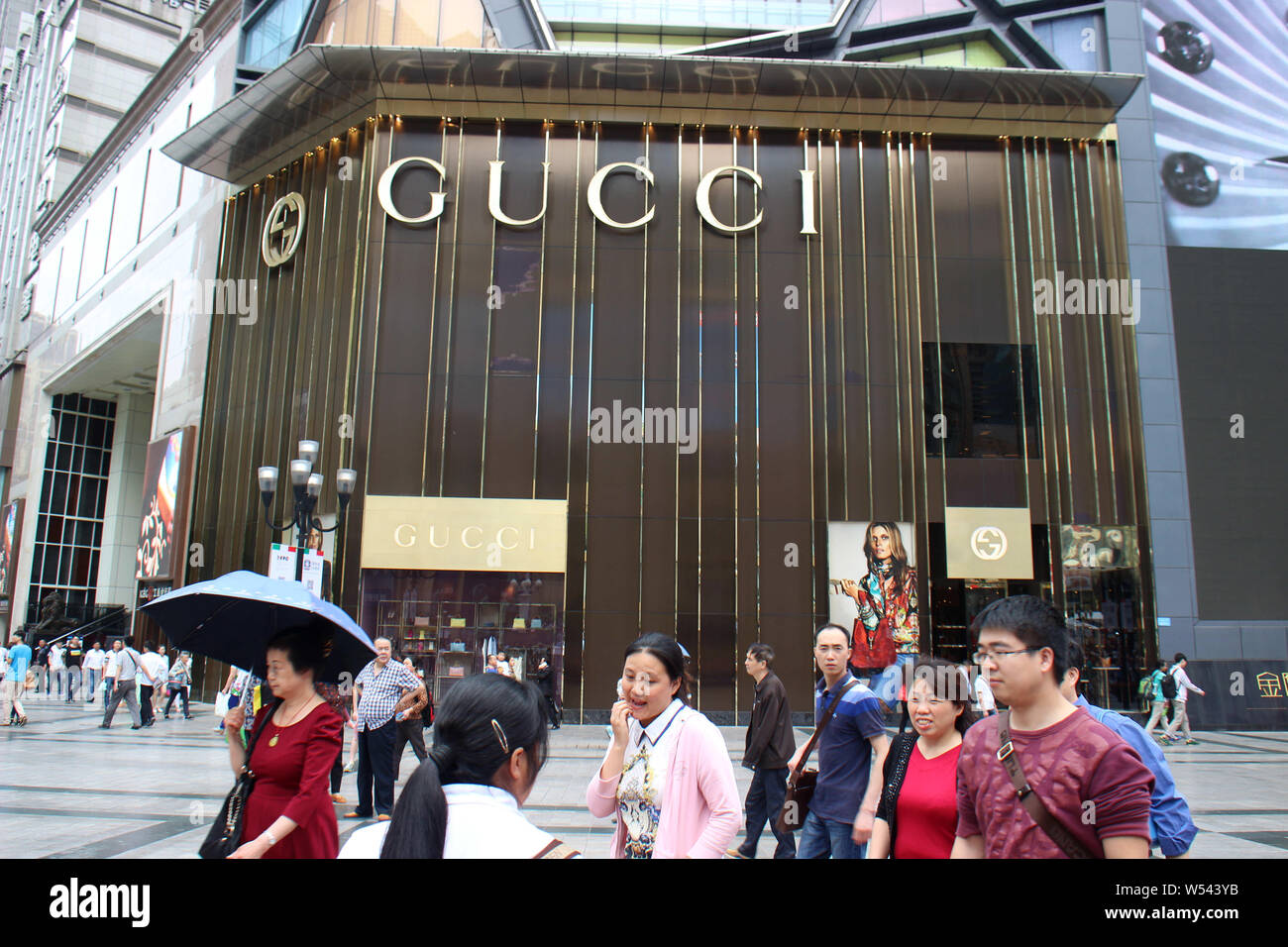 FILE--Pedestrians walk past a boutique store of Gucci in Chongqing, China,  2 May 2015. About half of Chinese consumers say they're planning to spe  Stock Photo - Alamy