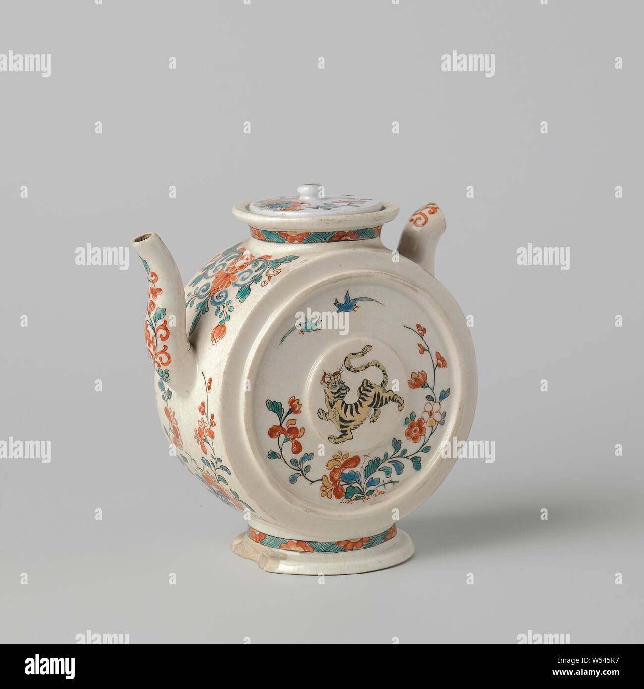 Teapot with a tiger, birds and floral scrolls, Teapot of soft-paste porcelain (pâte tendre) on foot and an S-shaped spout, painted on the glaze in blue, red, green, yellow, black and gold. The belly is in the form of a cylinder standing on the side, with a raised medallion and a raised circle on the flat wall. On the wall a tiger, two birds and a flowering plant. The round wall, the spout and the ear with flower vines. On the neck and foot a band with hatching interrupted by half flowers. The ear has largely broken off. Kakiemon style., anonymous, Japan, c. 1700 - c. 1799, Edo-period (1600 Stock Photo