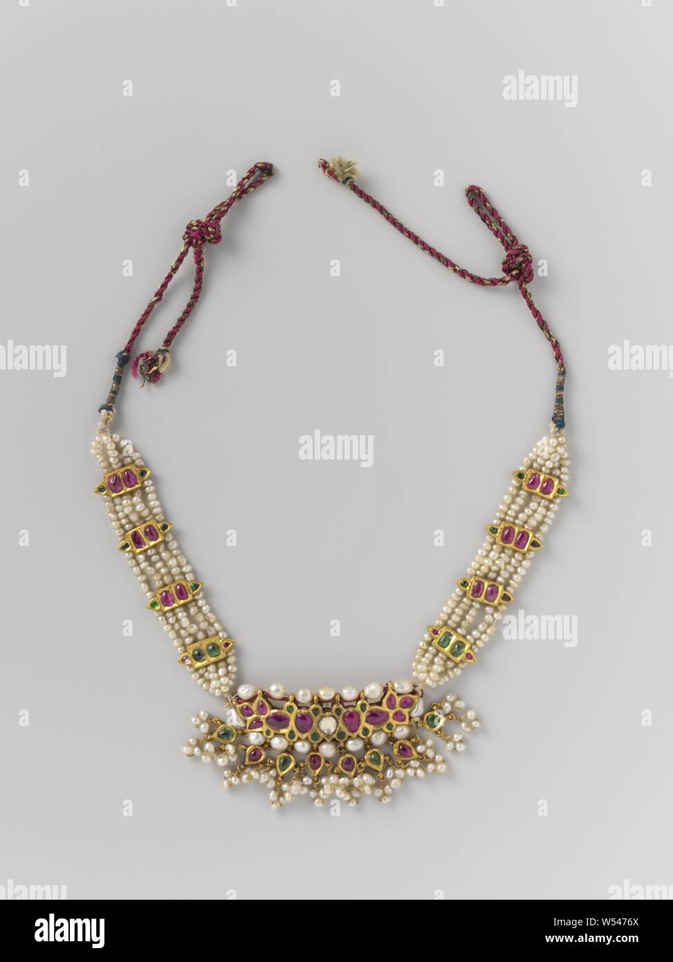 Necklace (kalyanti), Necklace (kalyanti) consisting of a golden center piece with red and green stones inlaid and with diamond splinters and pearls set. 8 leaf-shaped pendants hang from it, each with 3 clusters of 3 pearls. The center piece is supported by five strings of pearls that are held together in four places by golden brackets on each side., anonymous, Surat, c. 1750, gold (metal), diamond (mineral), pearl, w 31 cm × h 0.5 cm × d 4 cm Stock Photo