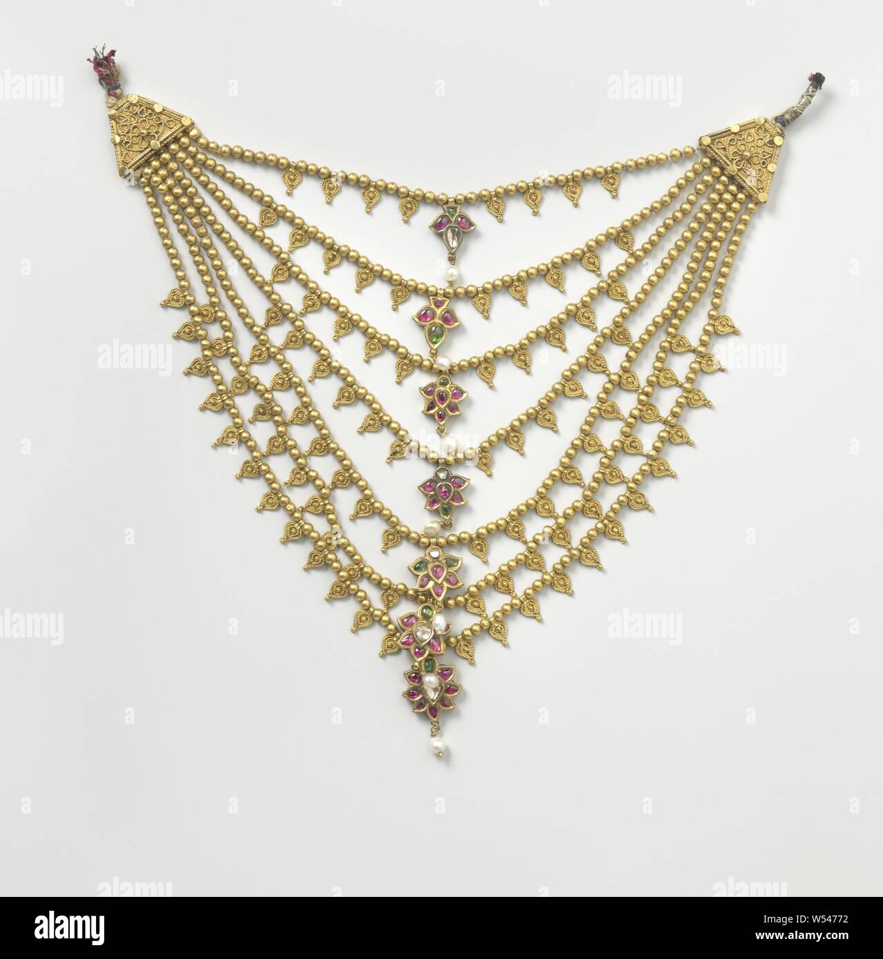 Necklace (candmala), A necklace (candmala) of gold consisting of seven cords. Each cord consists of a golden flower in the middle, inlaid with red and green stones and diamond splinters, supported by a cord of golden beads, interspersed with golden leaves and with a cap on both sides consisting of a filigree plate., anonymous, Surat, c. 1750, gold (metal), pearl, diamond (mineral), filigree, h 16.6 cm × w 16.5 cm Stock Photo
