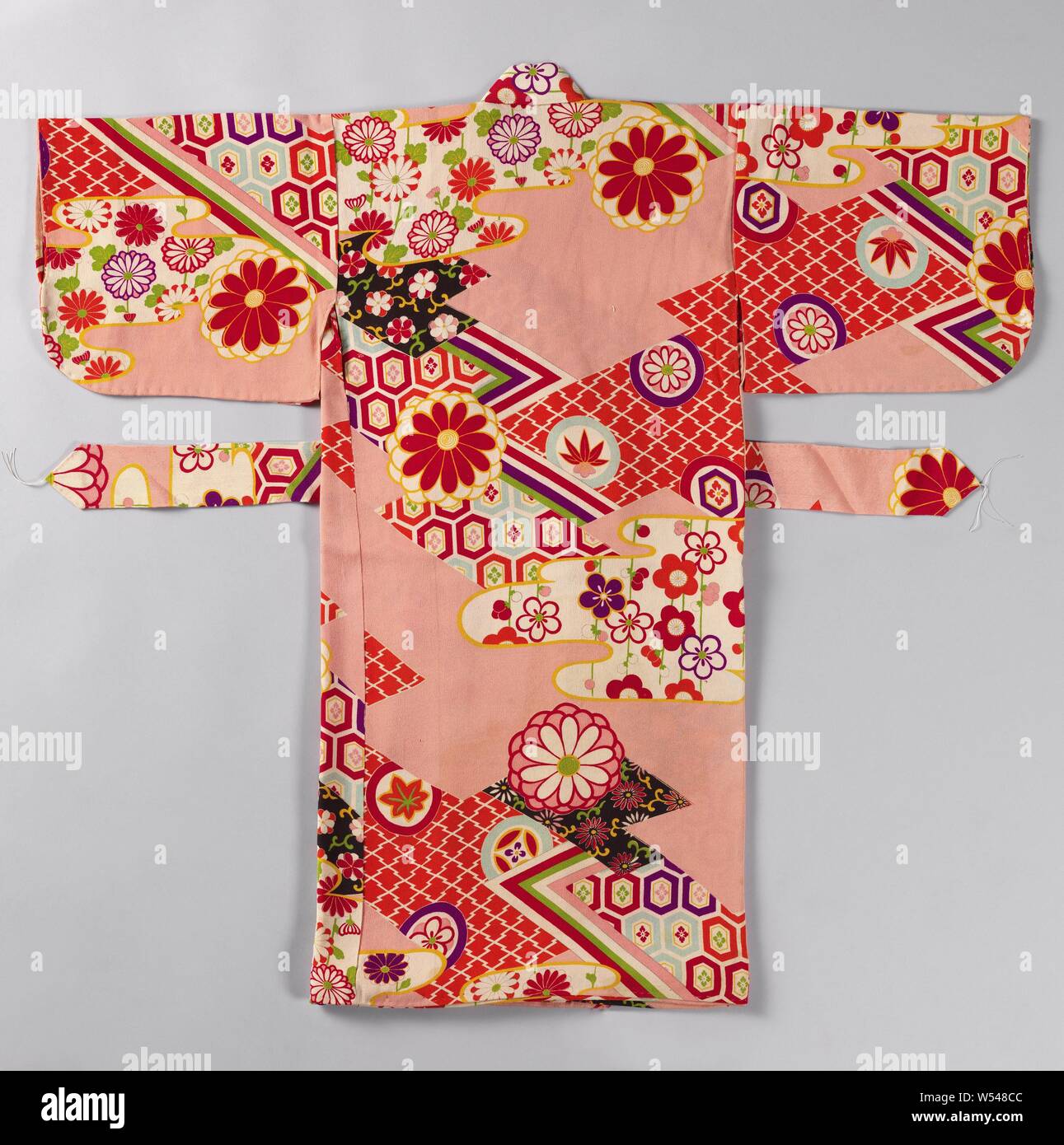 Girls miyamairi kimono with geometric and flower motifs, Formal kimono for a girl for the first visit to a Shinto shrine, with a decoration of angular and cloud-shaped surfaces with geometric patterns and motifs prunus, chrysanthemum and bamboo, against a pink background. Pink crepe silk (chirimen) with a stenciled yuzen decoration. Red silk lining with tie-dye decoration (shibori)., anonymous, Japan, 1920 - 1940, silk, painting, h 78 cm × w 70 cm Stock Photo