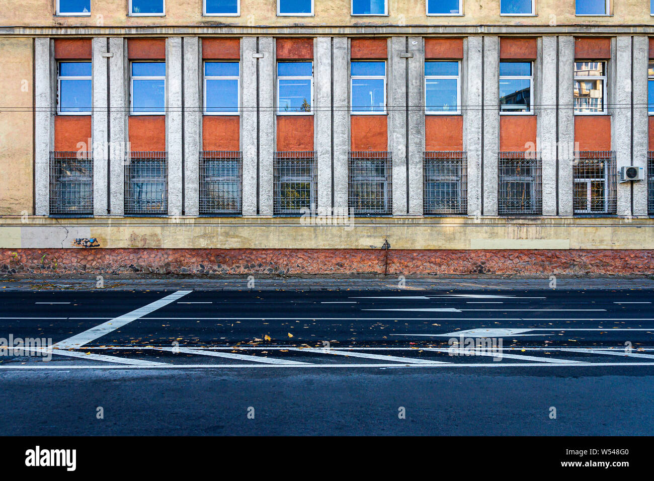 Close up of yellow and red wall with lots of windows. Architectural