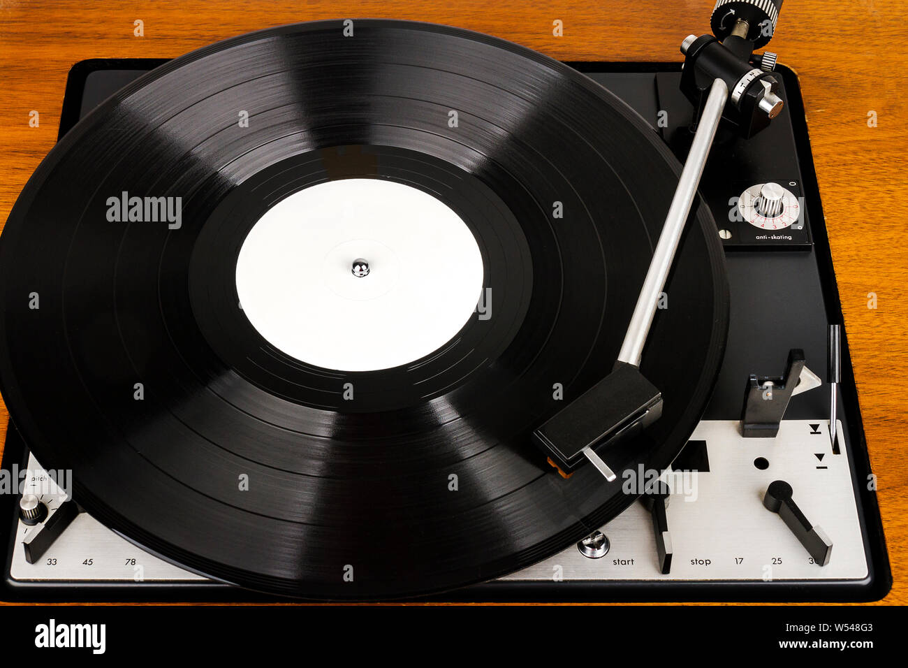 Close up of vintage turntable vinyl record player. Wooden plinth. Retro