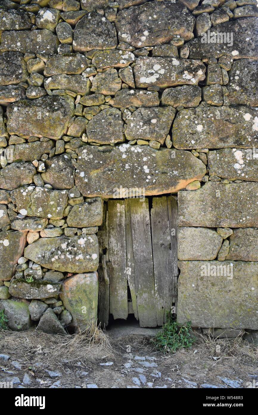 old wooden door on a stone wall with big stones Stock Photo - Alamy