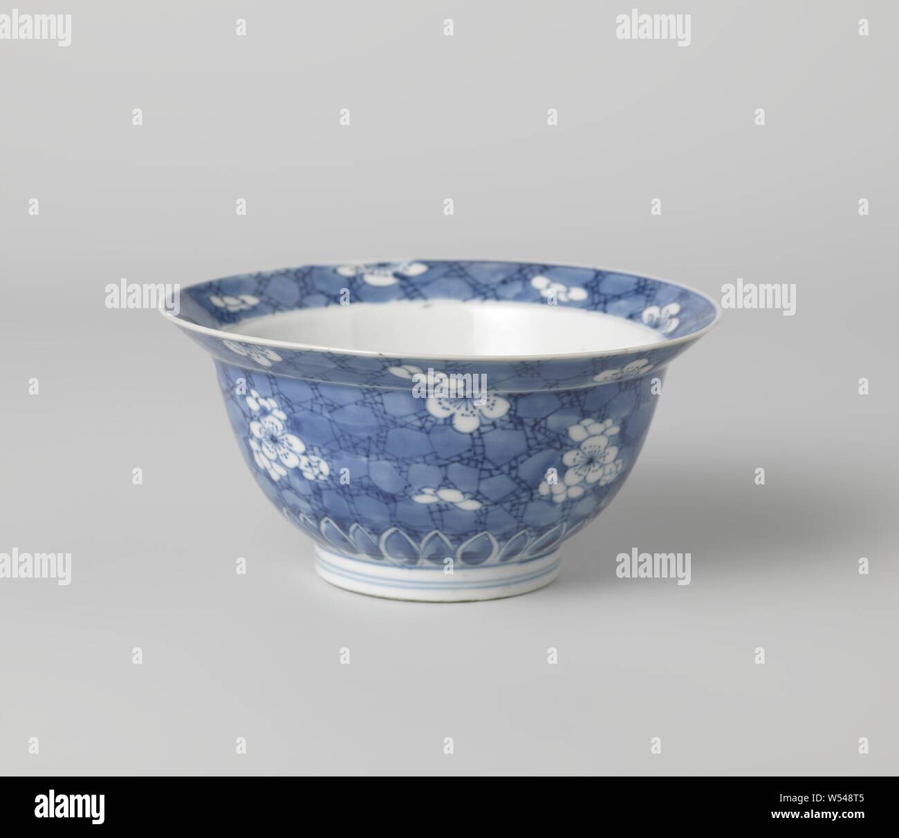 Bowl (folding hat) with plumblossom on 'crackled ice', Bowl (folding hat) of porcelain, painted in underglaze blue. On the outside wall, the bottom and inside and outside edge 'crackled ice' with recessed plum blossoms. The underside of the outer wall with a band of pointed leaf motifs. Marked on the bottom with an incense burner in a double circle. Blue White., anonymous, China, c. 1680 - c. 1720, Qing-dynasty (1644-1912) / Kangxi-period (1662-1722), porcelain (material), glaze, cobalt (mineral), painting, h 7.6 cm d 15.5 cm d 6.8 cm Stock Photo