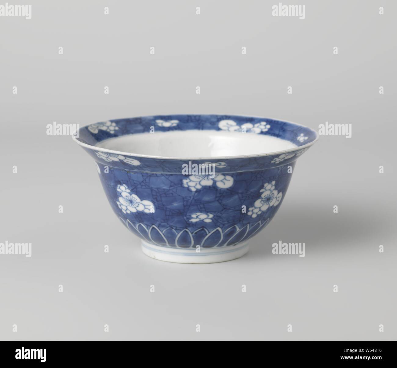 Bowl (folding hat) with plumblossom on 'crackled ice', Bowl (folding hat) of porcelain, painted in underglaze blue. On the outside wall, the bottom and inside and outside edge 'crackled ice' with recessed plum blossoms. The underside of the outer wall with a band of pointed leaf motifs. Marked on the bottom with an incense burner in a double circle. Blue White., anonymous, China, c. 1680 - c. 1720, Qing-dynasty (1644-1912) / Kangxi-period (1662-1722), porcelain (material), glaze, cobalt (mineral), painting, h 7.6 cm d 15.5 cm d 6.8 cm Stock Photo