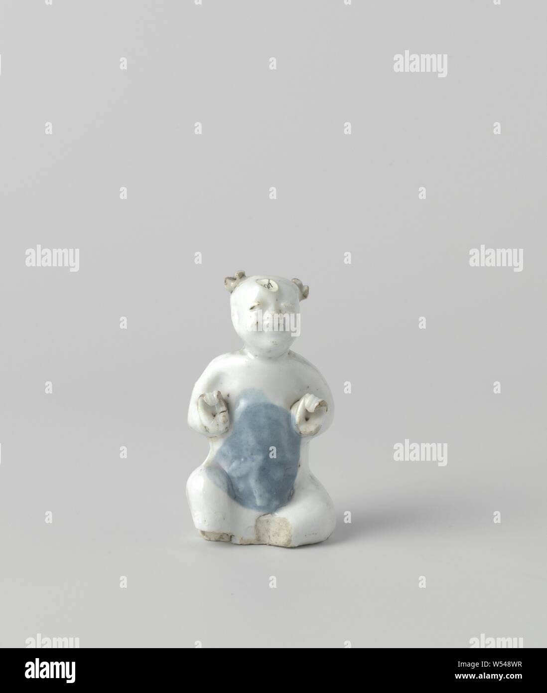 Figure of a seated boy, Porcelain statue, painted in underglaze blue. A seated boy. The feet are missing. Blue White., anonymous, China, c. 1573 - c. 1619, Ming-dynasty (1368-1644) / Wanli-period (1573-1619), porcelain (material), glaze, cobalt (mineral), vitrification, h 7.3 cm Stock Photo
