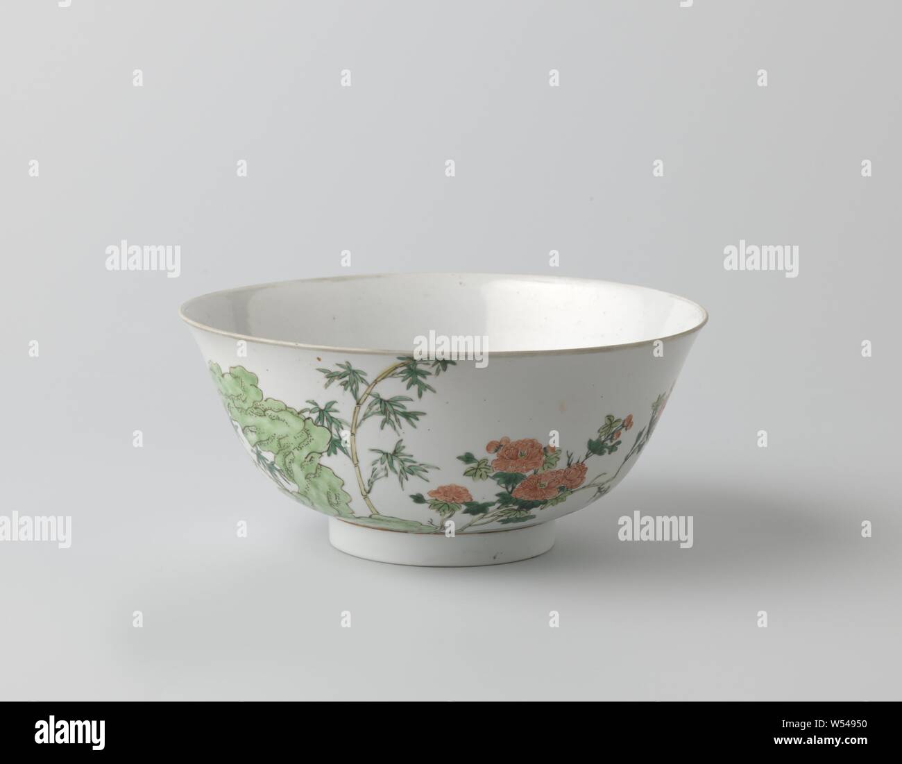 Bowl with peony, bamboo and maple tree near a rock, Porcelain bowl with spreading rim, painted in underglaze blue and on the glaze red, green, yellow and black. On the wall a large rock with a flowering peony, bamboo and a maple, two birds in the sky, a blooming lotus on the bottom. Marked on the underside with the six-character mark of emperor Hongzhi in a double circle. Famille verte., anonymous, China, c. 1700 - c. 1724, Qing-dynasty (1644-1912) / Kangxi-period (1662-1722) / Yongzheng-period (1723-1735), porcelain (material), glaze, cobalt (mineral), vitrification, h 9.5 cm d 21 cm d 9 cm Stock Photo