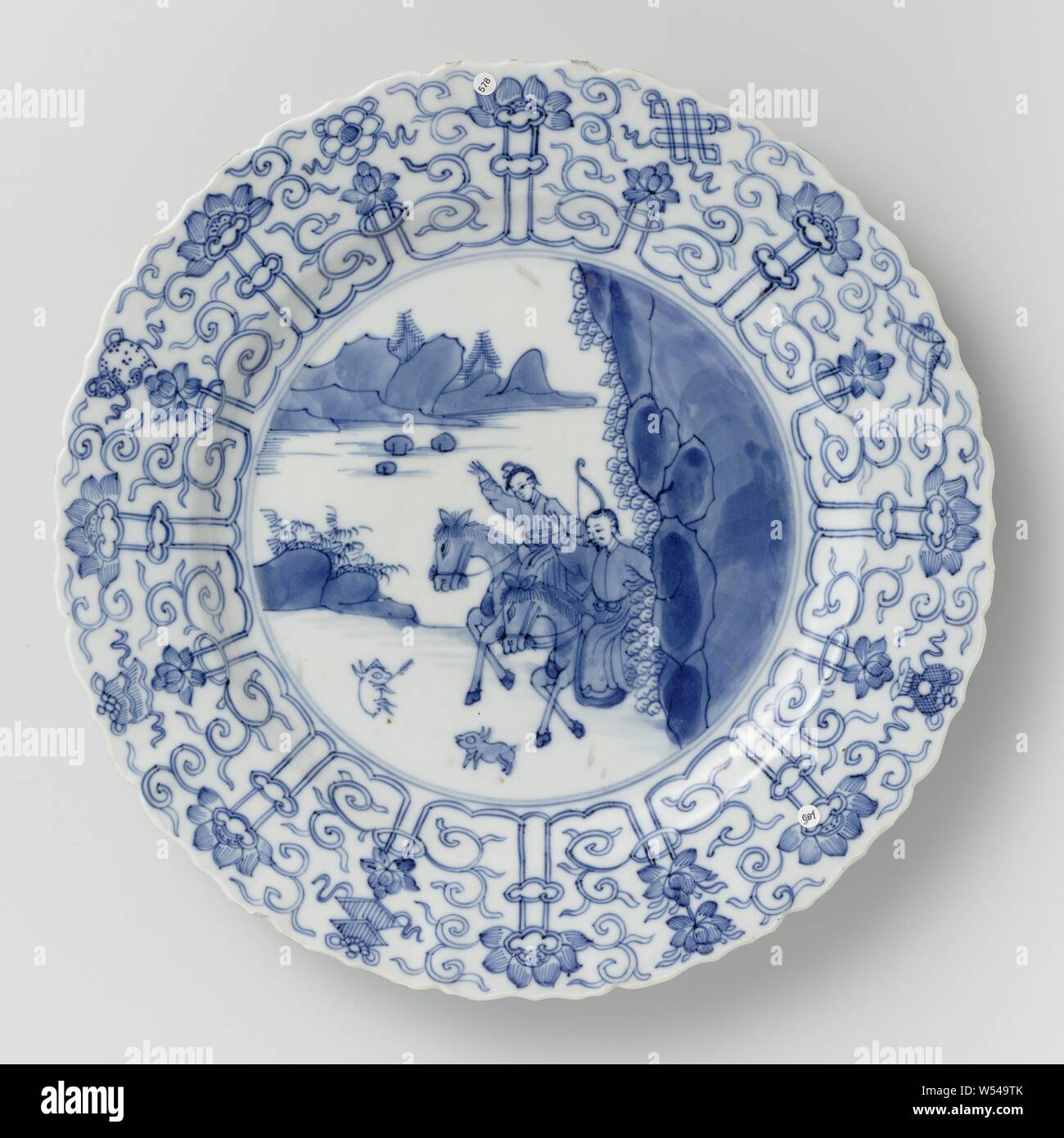 https://c8.alamy.com/comp/W549TK/saucer-dish-with-hunting-scene-lotus-scrolls-and-auspicious-symbols-porcelain-dish-with-round-ribbed-wall-and-scalloped-edge-painted-in-underglaze-blue-on-the-flat-a-hunting-scene-with-two-armed-horsemen-in-a-landscape-hunting-a-hare-the-border-with-a-concatenated-band-of-lotus-tendrils-between-which-the-eight-happiness-symbols-chakra-shell-parasol-canopy-lotus-vase-fish-infinite-knot-the-back-with-sixteen-separate-flower-sprays-marked-on-the-underside-with-the-six-character-mark-of-emperor-chenghua-in-a-double-circle-edge-slightly-damaged-blue-white-anonymous-china-c-W549TK.jpg