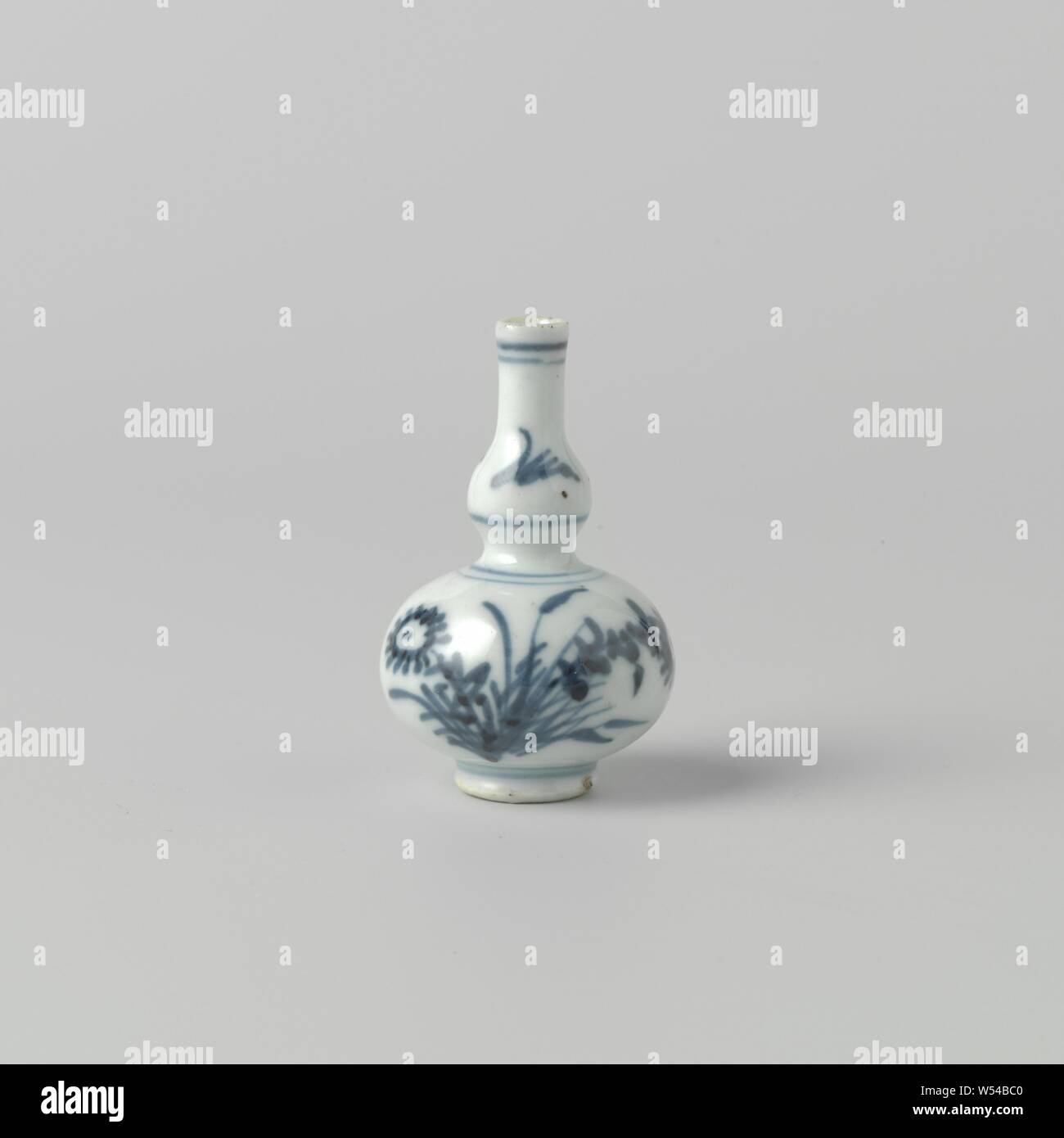 Miniature double gourd-shaped vase with flower sprays, Miniature gourd-shaped vase with a slightly spreading neck, painted in underglaze blue. On the belly a flower branch (aster) and loose twigs. Blue White., anonymous, China, c. 1675 - c. 1724, Qing-dynasty (1644-1912) / Kangxi-period (1662-1722) / Yongzheng-period (1723-1735), porcelain (material), glaze, cobalt (mineral), vitrification, h 6 cm Stock Photo